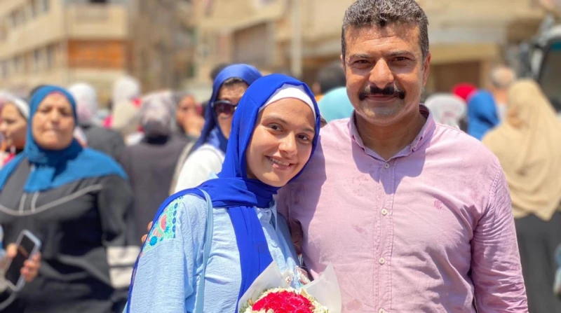 بورد وكيس تمر.. أب ينتظر ابنته أمام لجنة الثانوية العامة في مشهد مبهج جذب انتباه الجميع، وقف أب أمام لجنة امتحانات الثانوية العامة بمدينة الباجور