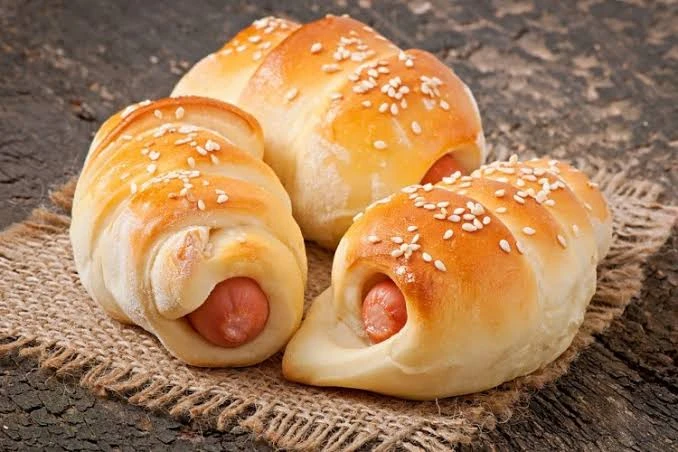 وصفة الهوت دوج بعجينة البف باستري.عدد 8 شرائح من البف باستريعدد 8 قطع من الهوت دوجكوب وربع من جبنة الشيدر المبشوربيضة مخفوقةسمسمحبة البركةالطريقة: قطعي البف باستري إلى مربعات متساو