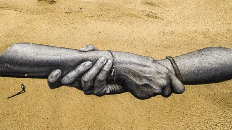 سواعد عملاقة متشابكة.. برقية سلام من خوفو ل إيفل أياد متشابكة على الرمال.. رسالة إنسانية للعالم بأهرامات الجيزة أياد عملاقة تتشبث ببعضها البعض، أمام أهرامات الجيزة المهيبة، للوهلة