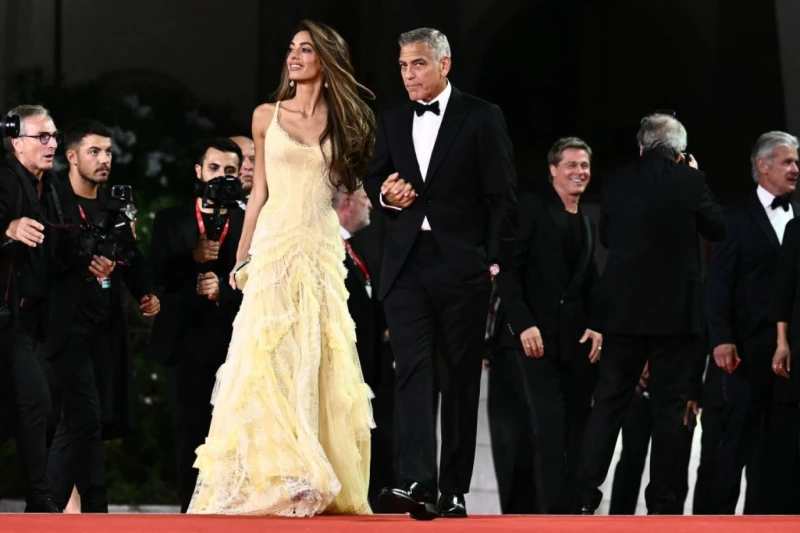 براد بيت مع صديقته وجورج كلوني يمازح المصوريين في السجادة الحمراء لفيلم عشرات من الجماهير اصطفوا قبالة السجادة الحمراء، تبدو عليهم الحماسة والسعادة، رافعين هواتفهم استعدادا للتصوير